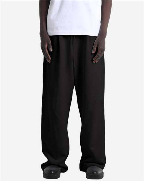 Shaka Wear Unisex Garment-Dyed Pleated Pants in Black, front view on model